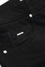 Close-up of a black pants pocket with a brand label.